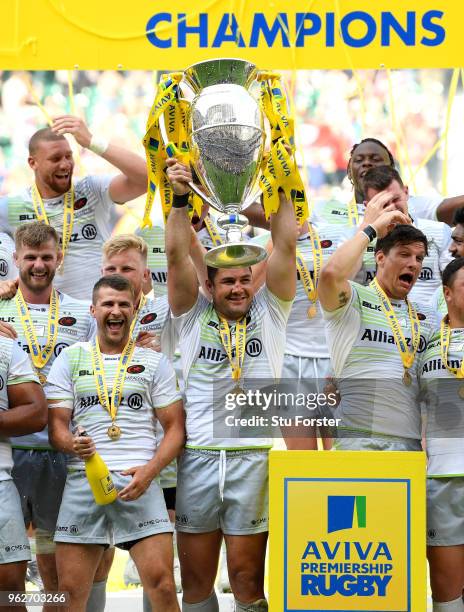 Saracens captain Brad Barritt lifts the trophy as his team mates celebrate after the Aviva Premiership Final between Exeter Chiefs and Saracens at...