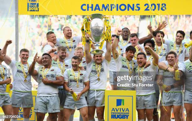 Saracens captain Brad Barritt lifts the trophy as his team mates celebrate after the Aviva Premiership Final between Exeter Chiefs and Saracens at...