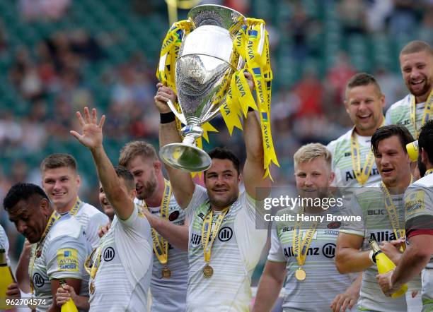 Brad Barritt of Saracens lifts the Aviva Premiership trophy following his side's victory during the Aviva Premiership Final between Saracens and...