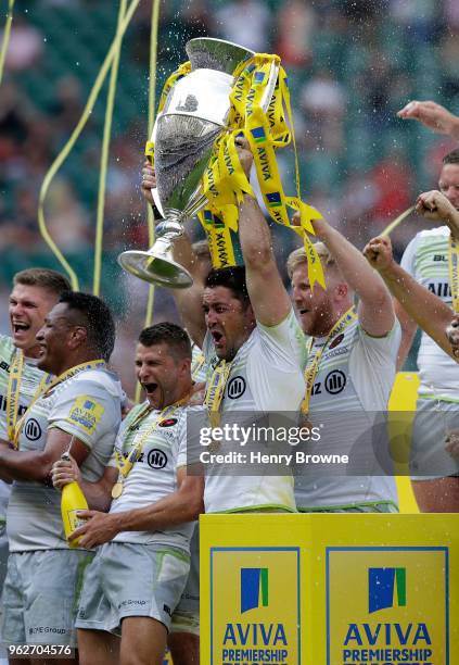 Brad Barritt of Saracens lifts the Aviva Premiership trophy following his side's victory during the Aviva Premiership Final between Saracens and...