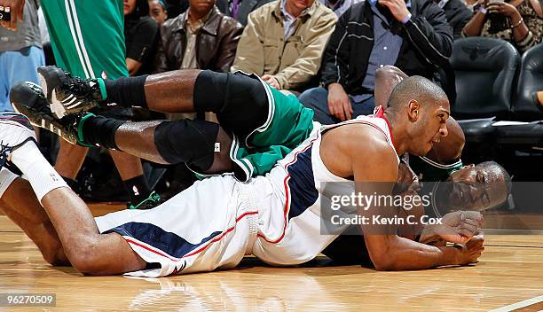 Al Horford of the Atlanta Hawks dives for a loose ball against Kendrick Perkins of the Boston Celtics at Philips Arena on January 29, 2010 in...