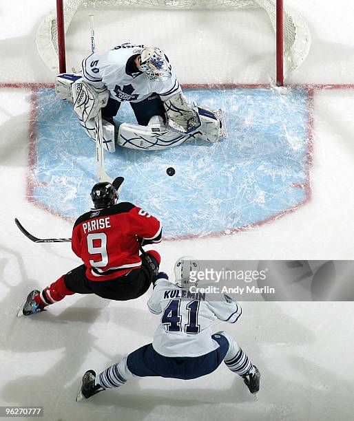 Jonas Gustavsson of the Toronto Maple Leafs makes a save as his teammate Nikolai Kuleman checks Zach Parise of the New Jersey Devils during their...