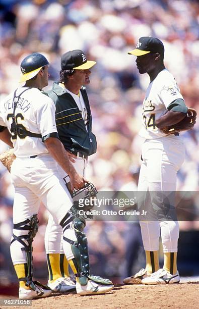 Manager Tony LaRussa of the Oakland Athletics speaks with pitcher Dave Stewart as catcher Terry Steinbach looks on during nn MLB game circa 1988 at...
