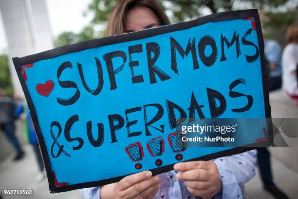 Woman holds &quot;Supermoms, superdads&quot; banner during &quot;Supermothers Day&quot; support action of RON strike in Warsaw on May 26, 2018.