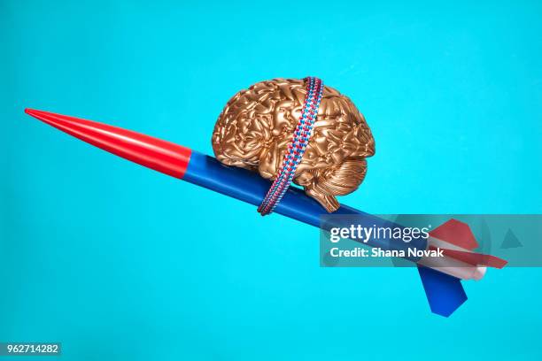 golden brain strapped to a rocket - genius concept stock pictures, royalty-free photos & images