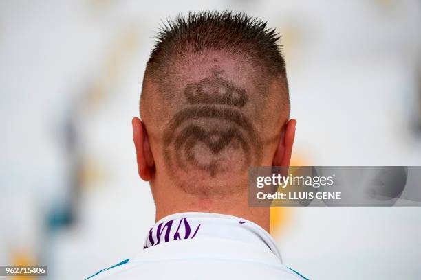 Real Madrid supporter poses showing his haircut shaped like the Real Madrid insignia before the UEFA Champions League final football match between...