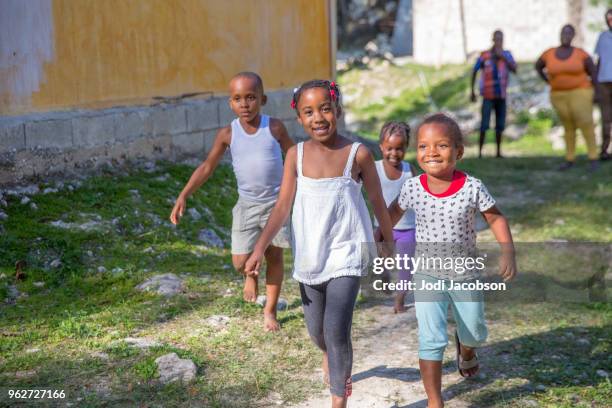 jamaican woman playing with children outdoors in saint irwin, an impoverished village in rural jamaica - jamaican girl stock pictures, royalty-free photos & images