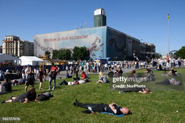 Soccer fans lay on the grass as waiting for the kick-off at the Maidan Square, near the fan zone, in doiwntown Kyiv, Ukraine, prior to the UEFA...