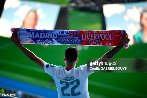 Real Madrid's fan wearing the jersey of Real Madrid's Spanish midfielder Isco brandishes a scarf prior to watch on a giant screen at the Santiago...