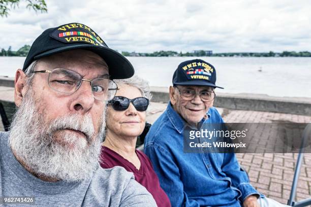senior adult usa military veterans family sitting at the lake - vietnam war photos stock pictures, royalty-free photos & images