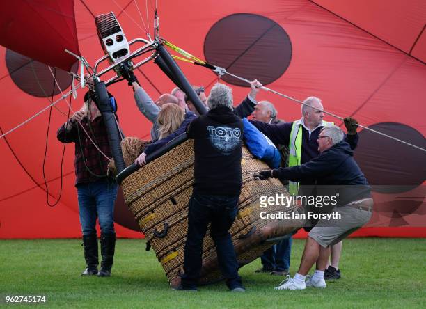 The basket of a hot air balloon tilts over as a balloon is inflated to test the strength of the wind as a decision is made about whether to carry out...