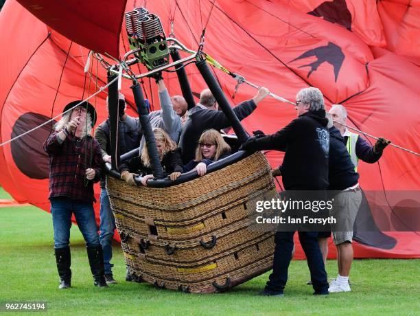 The basket of a hot air balloon tilts over as a balloon is inflated to test the strength of the wind as a decision is made about whether to carry out...