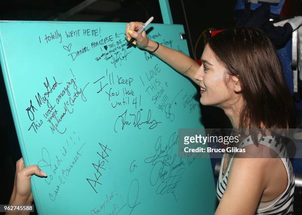 Lizzy Caplan signs the bathroom stall set backstage at the hit musical based on the film "Mean Girls" on Broadway at The August Wilson Theater on May...