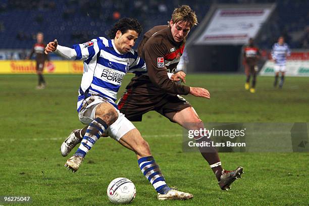 Olcay Sahan of Duisburg is challenged by Bastian Oczipka of St. Pauli during the Second Bundesliga match between MSV Duisburg and FC St. Pauli at MSV...