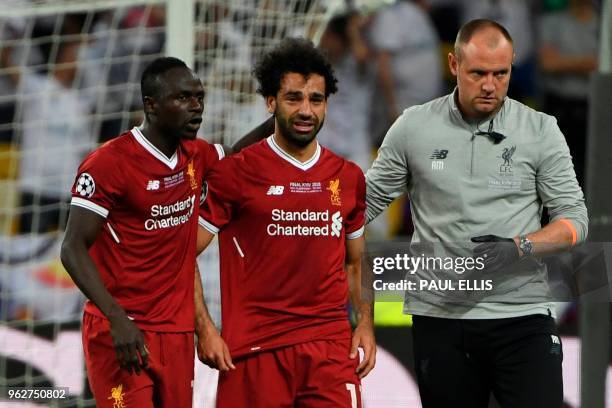 Liverpool's Egyptian forward Mohamed Salah reacts as he is forced the leave the pitch after hurting his shoulder in a challenge with Real Madrid's...