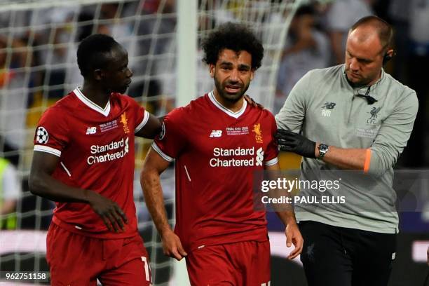 Liverpool's Egyptian forward Mohamed Salah reacts as he is forced the leave the pitch after hurting his shoulder in a challenge with Real Madrid's...