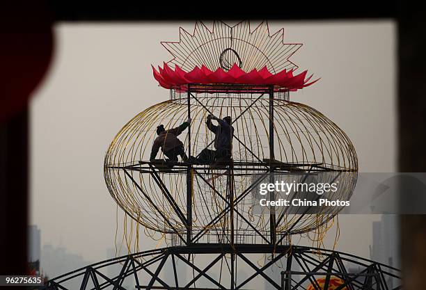 Workers install a giant light decoration for the upcoming Chinese new year at the South Gate of Xian City Wall on January 29, 2010 in Xian of Shaanxi...