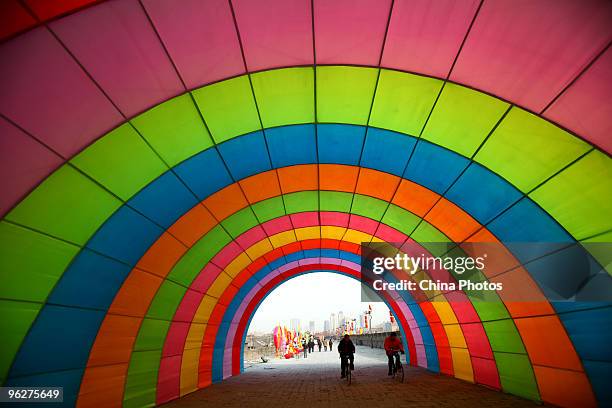 Tourists pedal through a giant light decorations installed for the upcoming Chinese new year at the South Gate of Xian City Wall on January 29, 2010...