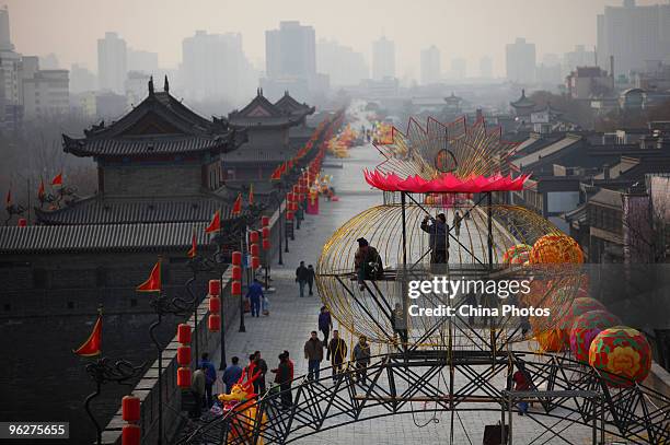 Workers install a giant light decoration for the upcoming Chinese new year at the South Gate of Xian City Wall on January 29, 2010 in Xian of Shaanxi...