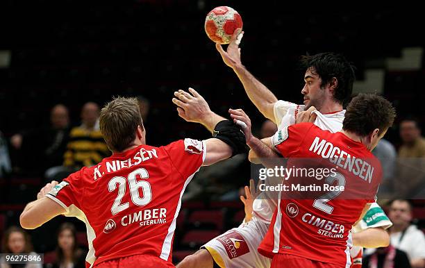 Kasper Nielsen and Thomas Mogensen of Denmark try to block Raul Entrerrios of Spain during the Men's Handball European qualifyer place 5 match...