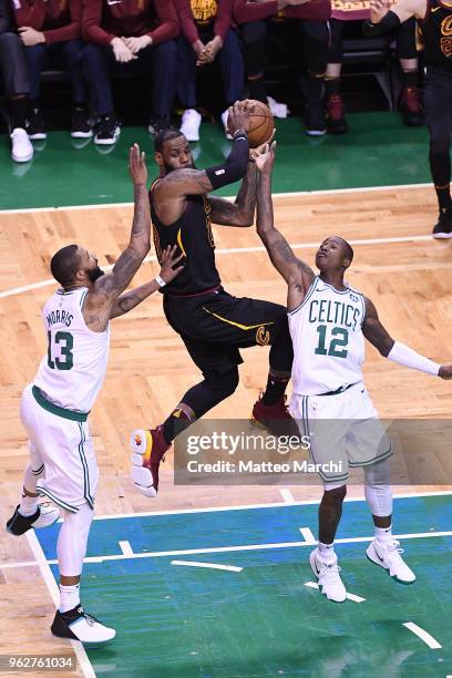 LeBron James of the Cleveland Cavaliers passes the ball against Terry Rozier and Marcus Morris of the Boston Celtics during Game Five of the 2018 NBA...