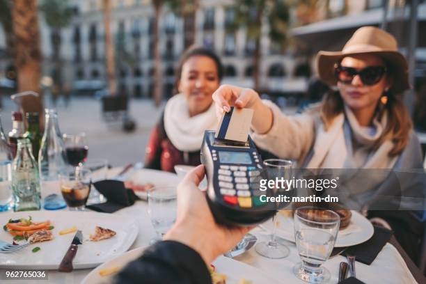 woman payng in restaurant - paying for dinner imagens e fotografias de stock