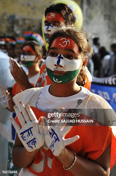 An Indian student shows her palms painted with the message "We all are one" during a peace march to mark the death anniversary of India's founding...