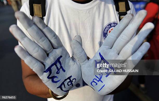 An Indian student shows her palms painted with the message "We all are one" during a peace march to mark the death anniversary of India's founding...
