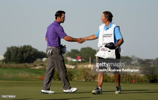Paul Casey of England shakes hands with his caddie Christian Donald on the 18th hole during the third round of the Commercialbank Qatar Masters at...