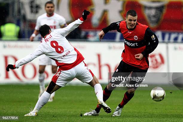 Alexander Meier of Frankfurt is challenged by Petit of Koeln during the Bundesliga match between Eintracht Frankfurt and 1. FC Koeln at the...