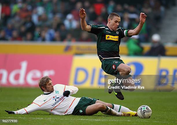 Aaron Hunt of Bremen slides into Filip Daems of Moenchengladbach during the Bundesliga match between Borussia Moenchengladbach and SV Werder Bremen...