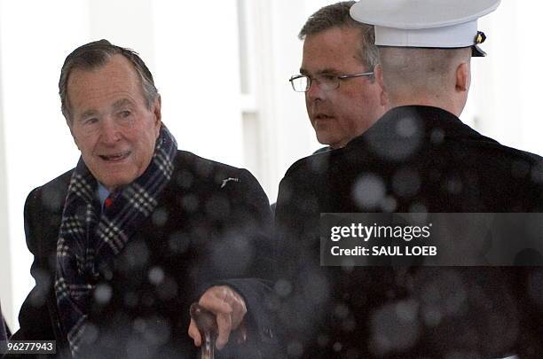 Former US President George H.W. Bush and his son, former Florida Governor Jeb Bush , arrive at the West Wing of the White House in Washington on...