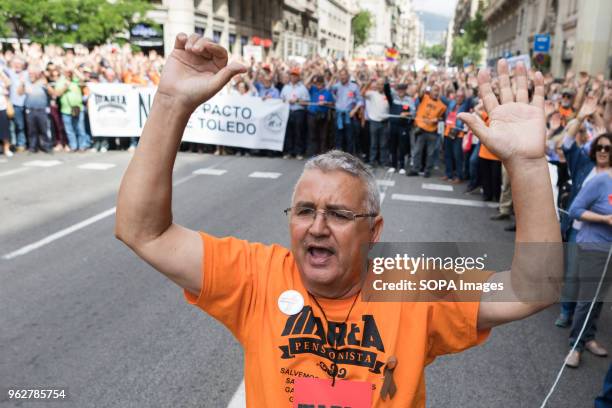 Man raising arms and wearing orange t-shirt, colour of the organization that called for the rally, Marea Pensionista. Hundreds or people rally in the...