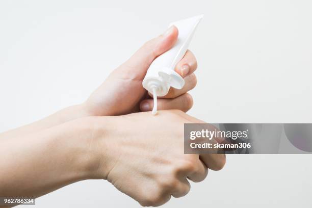 hand use skin cream with skin cream and lotion bottle - cream coloured stock pictures, royalty-free photos & images