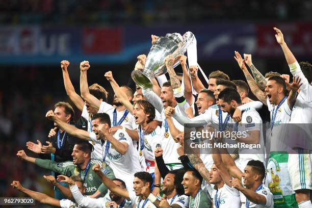 Sergio Ramos of Real Madrid lifts The UEFA Champions League trophy as his teammates celebrate following their sides victory in the UEFA Champions...