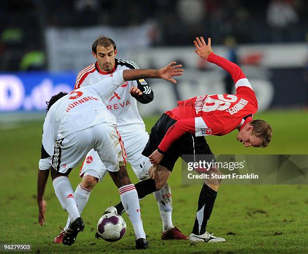 Jan Rosenthal of Hannover is challenged by Breno and Javier Pinola of Nuernberg during the Bundesliga match between Hannover 96 and FC Nuernberg at...