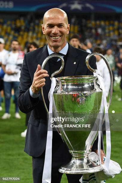 Real Madrid's French coach Zinedine Zidane holds the trophy as he celebrates winning the UEFA Champions League final football match between Liverpool...