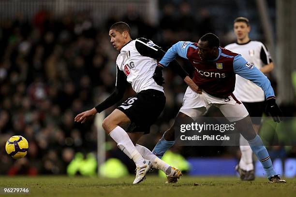Chris Smalling of Fulham holds off the challenge from Emile Heskey of Aston Villa during the Barclays Premier League match between Fulham and Aston...