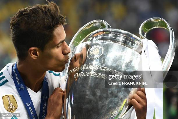 Real Madrid's French defender Raphael Varane kisses the trophy as he poses after winning the UEFA Champions League final football match between...