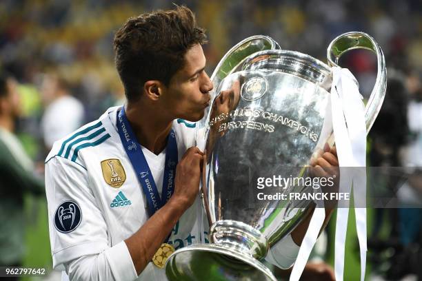 Real Madrid's French defender Raphael Varane kisses the trophy as he poses after winning the UEFA Champions League final football match between...