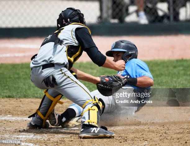 Demarques Ortega, #33, Mountain Range, slides into home, but is called out against Arapahoe catcher Zach Goodman, #23, in the second inning during...