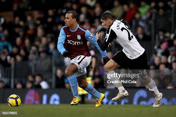 Gabriel Agbonlahor of Aston Villa is pursued by Chris Smalling of Fulham during the Barclays Premier League match between Fulham and Aston Villa at...