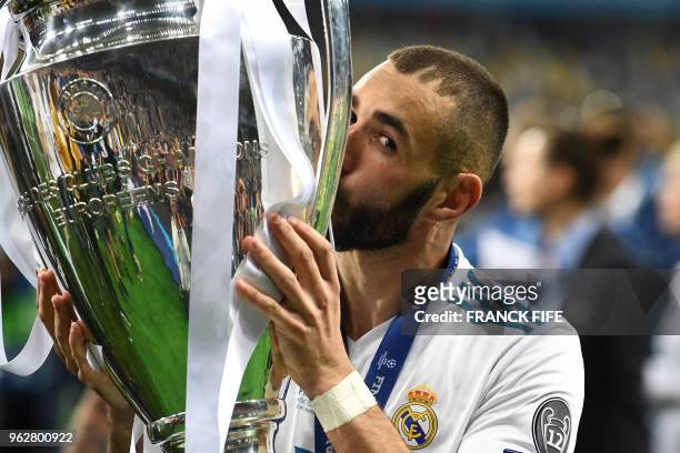Real Madrid's French forward Karim Benzema kisses the trophy as he celebrates winning the UEFA Champions League final football match between...