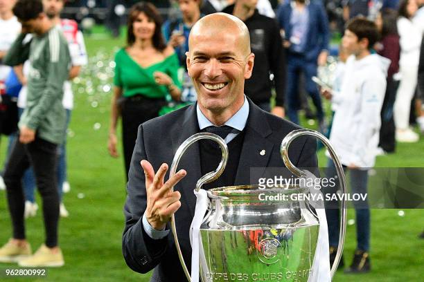 Real Madrid's French coach Zinedine Zidane poses with the trophy after winning the UEFA Champions League final football match between Liverpool and...