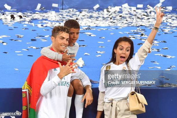 Real Madrid's Portuguese forward Cristiano Ronaldo poses with his girlfriend Georgina Rodriguez and his son Cristiano Jr after his team won the UEFA...