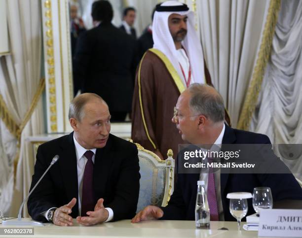 Russian President Vladimir Putin talks to Chairman of the Russian Fund for Direct Investments Kirill Dmitriev during a meeting with foreign investors...