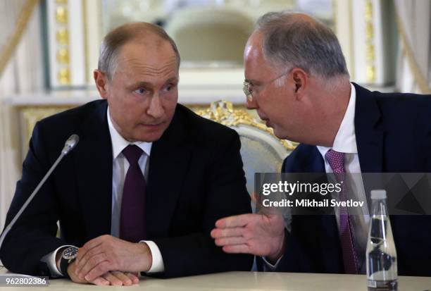 Russian President Vladimir Putin listens to Chairman of the Russian Fund for Direct Investments Kirill Dmitriev during a meeting with foreign...