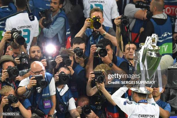 Real Madrid's Portuguese forward Cristiano Ronaldo poses with the trophy after his team won the UEFA Champions League final football match between...