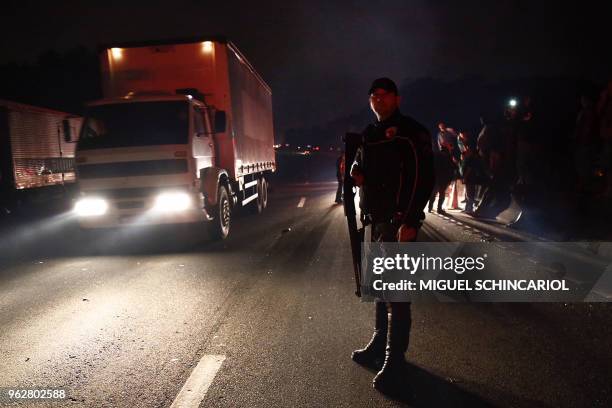 Brazilian Military Police officer stands guard during an operation to clear blocked "Rodoanel Mrio Covas" road in the city of Sao Bernardo do Campo,...