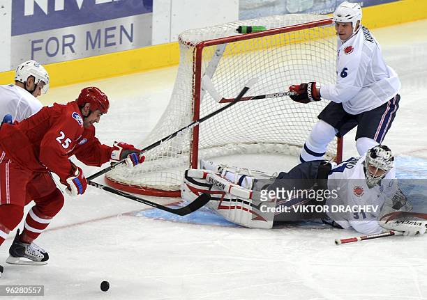 Danis Zaripov of the Alexey Yashin team, red, vies for the puck with Karri Ramo , and Lasse Kukkonen of the Jaromir Jagr team, white, during the...